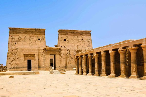 Temple of Philae in Aswan with ancient columns and carvings under a blue sky.