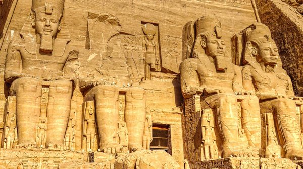 Statue monumentale di Abu Simbel in Egitto con dettagli scolpiti e illuminazione solare.