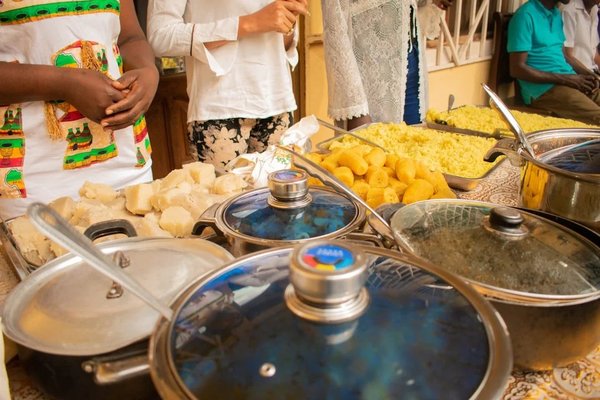 Nubian cooking class in Aswan with traditional dishes and people in traditional attire.