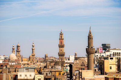 Panoramic view of Cairo's historic minarets and architecture under a clear blue sky.