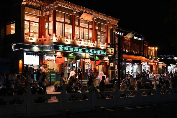 Night market in Beijing with traditional Chinese architecture and bright neon signs.