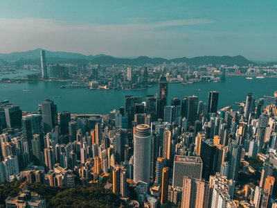 Night panoramic view of Hong Kong skyline with Victoria Harbour and illuminated skyscrapers.