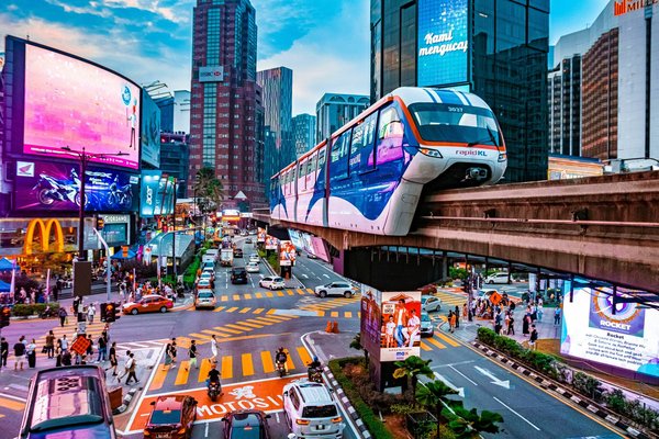 View of Bukit Bintang district in Kuala Lumpur with Rapid KL monorail and vibrant neon lights.
