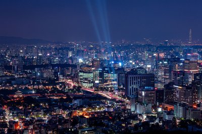 Vista notturna dello skyline di Seoul con luci brillanti e la Torre Lotte World in lontananza.
