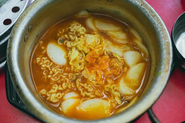Pentola di tteokbokki con ramen e salsa piccante in un mercato di strada a Seoul.
