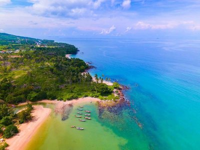 Panoramic view of Ko Samui with tropical beach, boats, and crystal-clear sea.