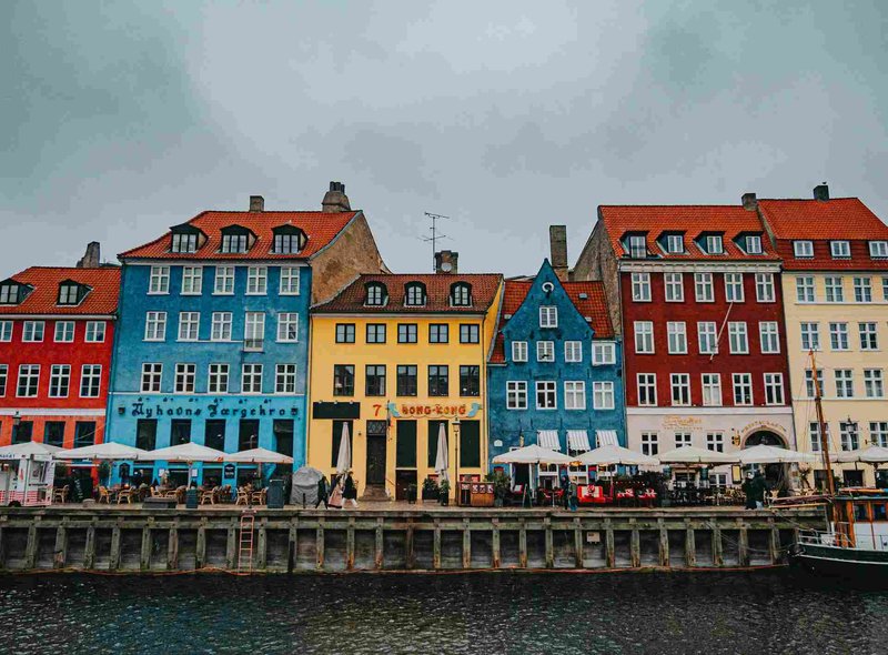 Edifici colorati lungo il canale di Nyhavn a Copenaghen in una giornata nuvolosa.