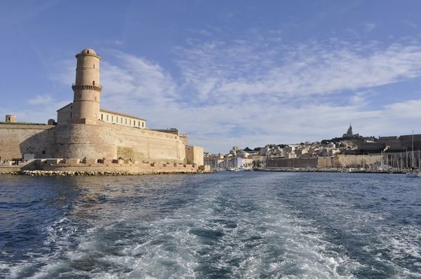 Vista del Forte Saint-Jean e del Porto Vecchio di Marsiglia con cielo limpido e acqua blu.