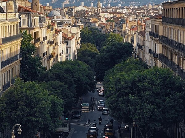 Vista panoramica di La Canebière a Marsiglia con edifici storici e alberi lungo la strada.