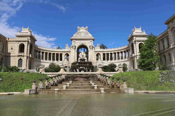 Vista del Palais Longchamp a Marsiglia con fontana centrale e cielo blu.