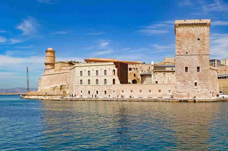Vista del Fort Saint-Jean a Marsiglia con cielo blu e mare calmo.