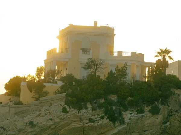 Villa su una scogliera al tramonto lungo la Corniche Kennedy a Marsiglia, con vegetazione e vista sul mare.