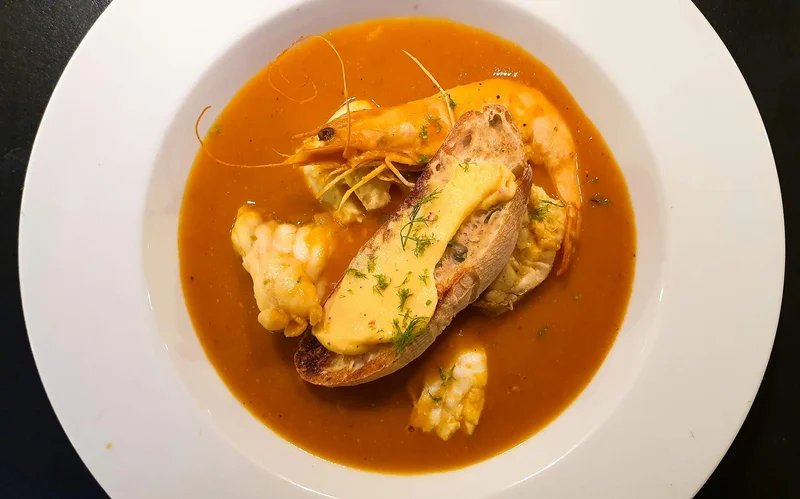 Piatto di bouillabaisse con gamberi, pesce e crostino, tipico di Marsiglia.