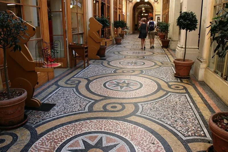 Paris covered passage with mosaic flooring and shops on the sides.