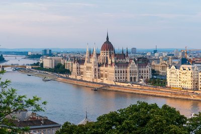 View of the Hungarian Parliament and the Danube River in Budapest at sunset.