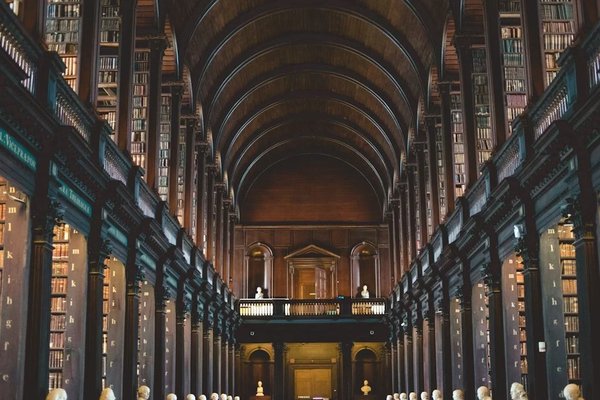 Interior of the Long Room Library at Trinity College in Dublin, with bookshelves and arched wooden ceiling.
