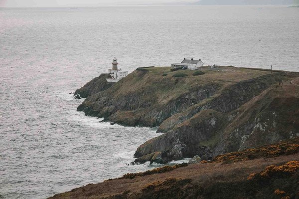 View of Howth lighthouse and surrounding cliffs with the sea in the distance, a famous attraction near Dublin.