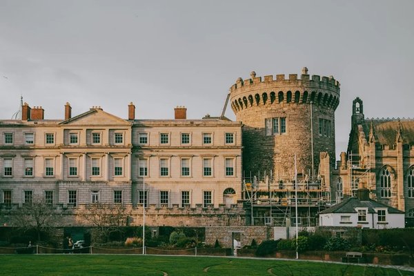 View of Dublin Castle with medieval tower and historic building at sunset.