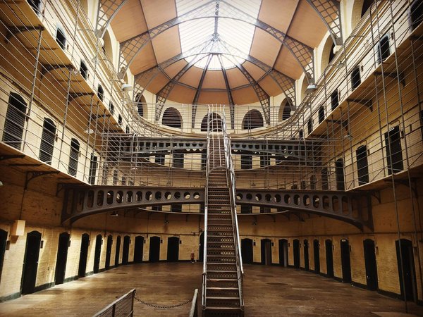 Interior of Kilmainham Gaol in Dublin, featuring central staircase and iron balconies.