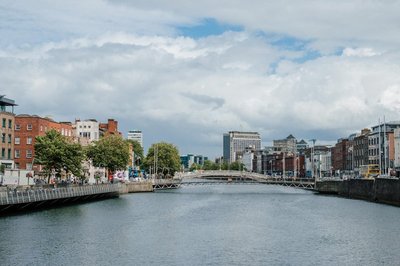 Panoramic view of the River Liffey and bridge in Dublin with historic and modern buildings in the background.