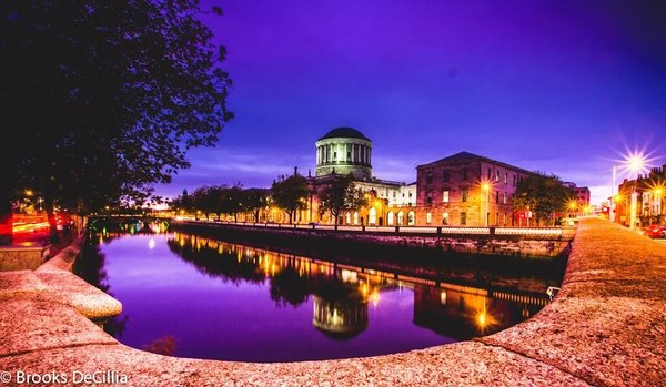 Night view of the River Liffey and the Four Courts in Dublin with lights reflecting on the water.