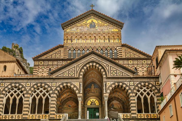 Facade of Amalfi Cathedral with architectural details and golden mosaics.