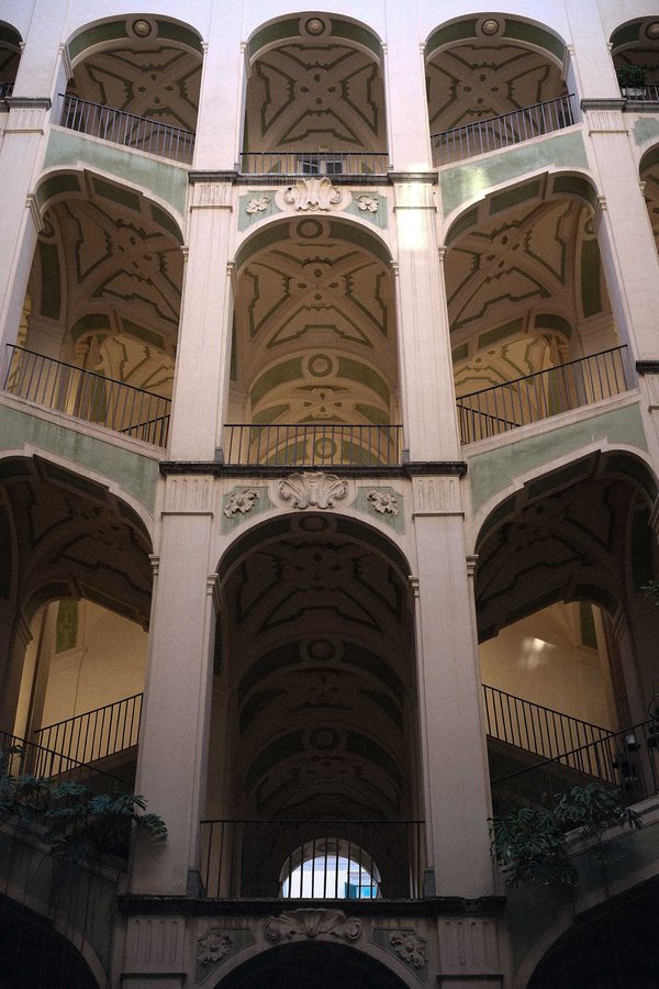 Vista interna del Palazzo dello Spagnolo a Napoli con archi barocchi e dettagli decorativi.