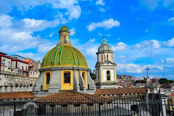 Cupola della Basilica di Santa Maria della Sanità a Napoli con cielo blu e edifici circostanti.