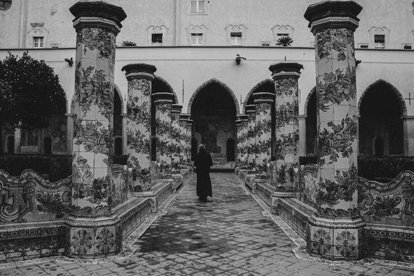 Chiostro con colonne decorate da maioliche nel Complesso Monumentale di Santa Chiara a Napoli, in bianco e nero.