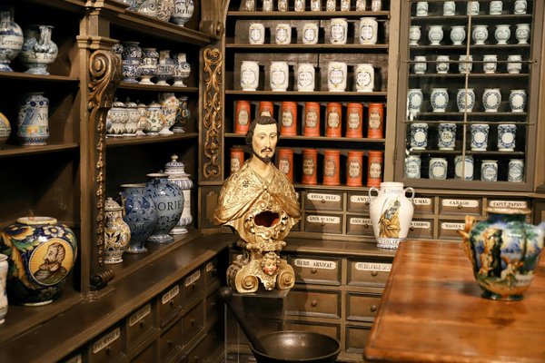 Interno della Farmacia degli Incurabili a Napoli con vasi antichi e decorazioni ornate.