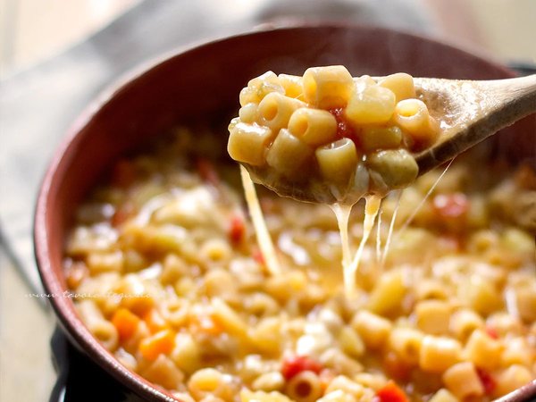 Traditional Neapolitan pasta served hot with melted cheese, typical of Trattoria Nennella in Naples.
