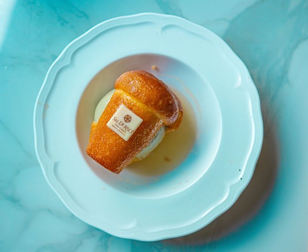 A golden rum-soaked baba pastry served with a scoop of ice cream.