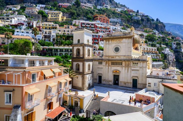 Panoramic view of Positano with distinctive colorful buildings cascading down the clifftside above the Tyrrhenian Sea.