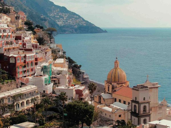 View of Positano with the Church of Santa Maria Assunta and its iconic yellow dome near the sea.