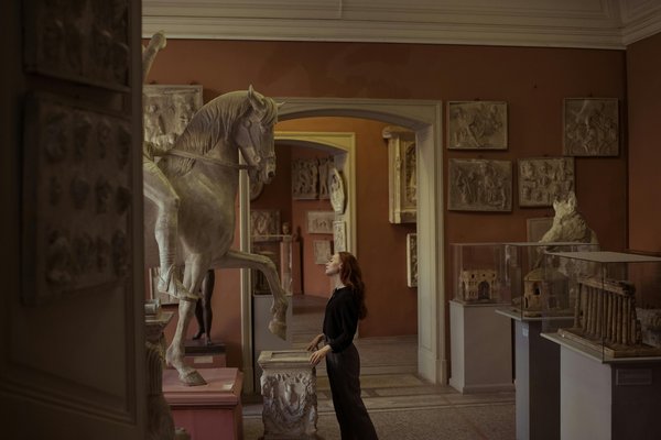 Interno del Museo Correale a Sorrento con una statua di cavallo e una visitatrice che osserva le opere d'arte.