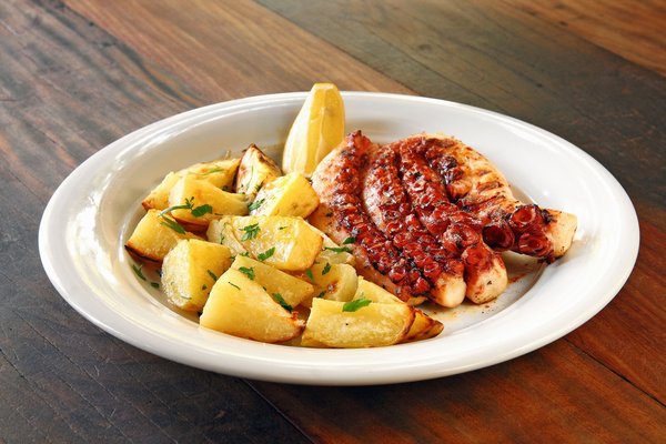 Grilled octopus with roasted potatoes and lemon, a signature dish at Bagni Delfino in Sorrento.