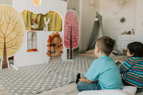 Bambini che guardano uno spettacolo di burattini in un ambiente accogliente, ideale per attivita teatrali per bambini.