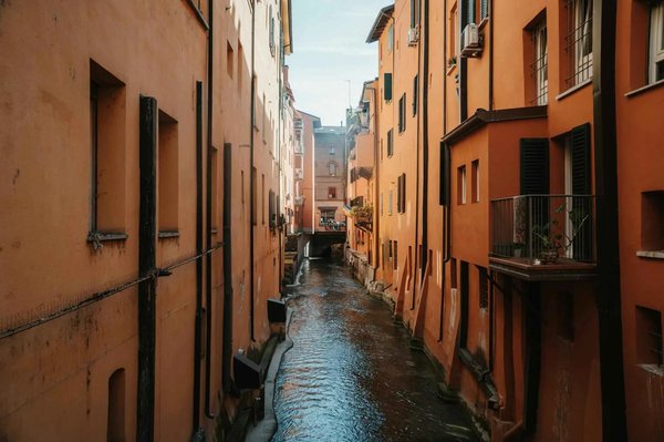 View of the Moline Canal in Bologna with orange buildings and reflections on the water.