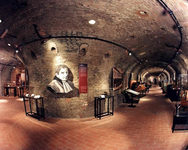 Interior of the Museum of Industrial Heritage in Bologna with exposed bricks and historical exhibits.