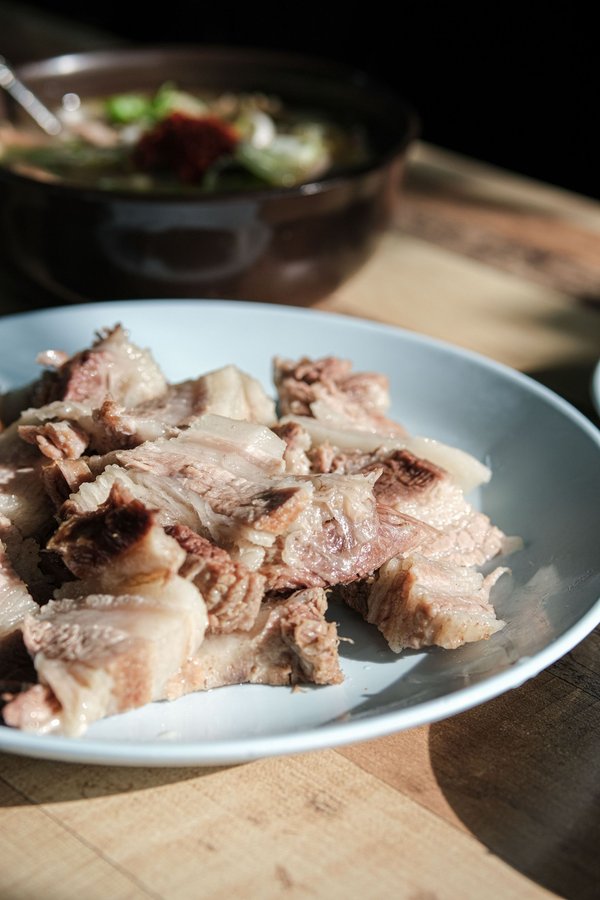 Piatto di carne su un tavolo di legno con sfondo sfocato.