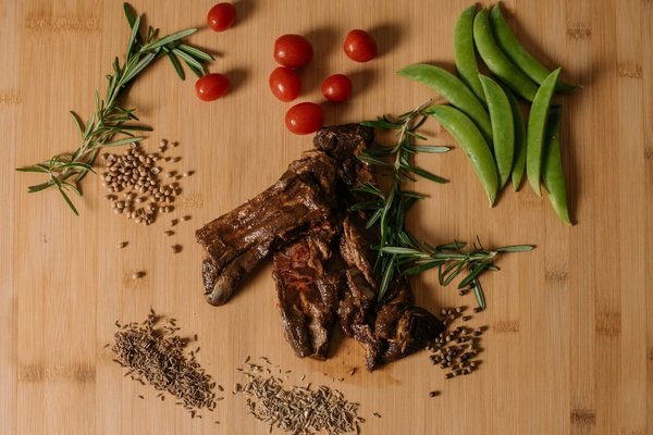 Grilled lamb chops with fresh rosemary, cherry tomatoes, and snap peas.