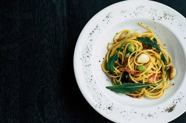 Elegantly plated pasta dish with herb garnish, fine-dining presentation.