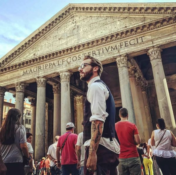 View of the Pantheon in Rome with tourists in the foreground, highlighting the historic architecture and lively atmosphere.