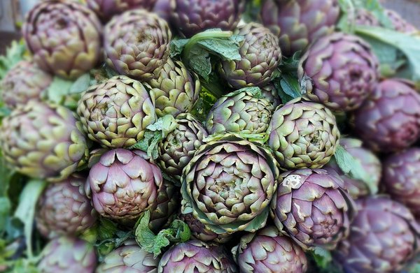 Fresh whole artichokes at a market, the key ingredient of carciofi alla giudia.