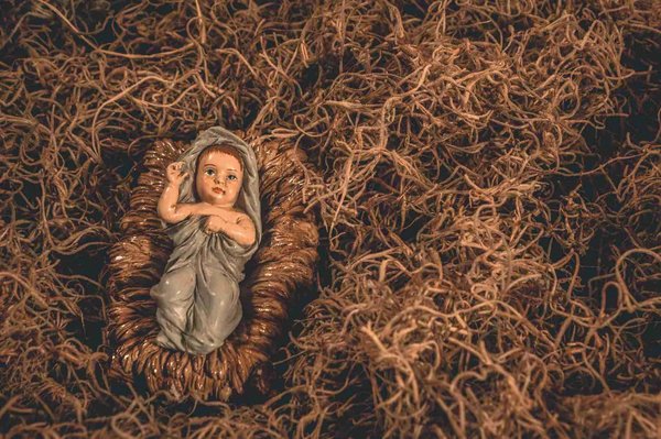 Scena della Natività con statuetta del Bambino Gesù su paglia, tipica del Natale a Trastevere, Roma.