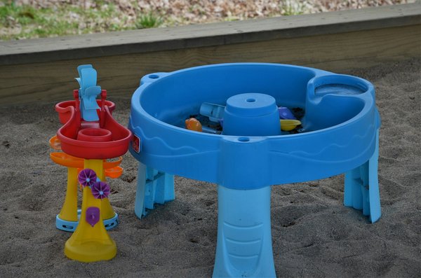 Colorato tavolo per il gioco con l'acqua con una ruota a mulino per l'esperienza idraulica pratica.
