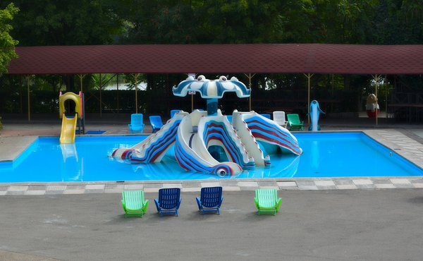Piscina per bambini con una struttura di scivoli a forma di fungo in un parco acquatico.