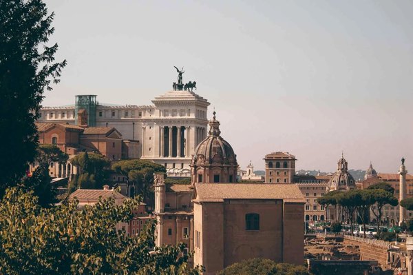 Vista del Foro Romano con l'Altare della Patria e cupole storiche a Roma, Italia, in una giornata soleggiata.