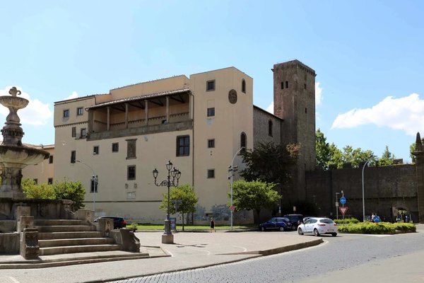 View of Rocca Albornoz in Viterbo, home to the National Etruscan Museum, with a fountain and road in the foreground.