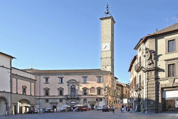 Plebiscito Square in Viterbo with clock tower and historic buildings under a clear sky.